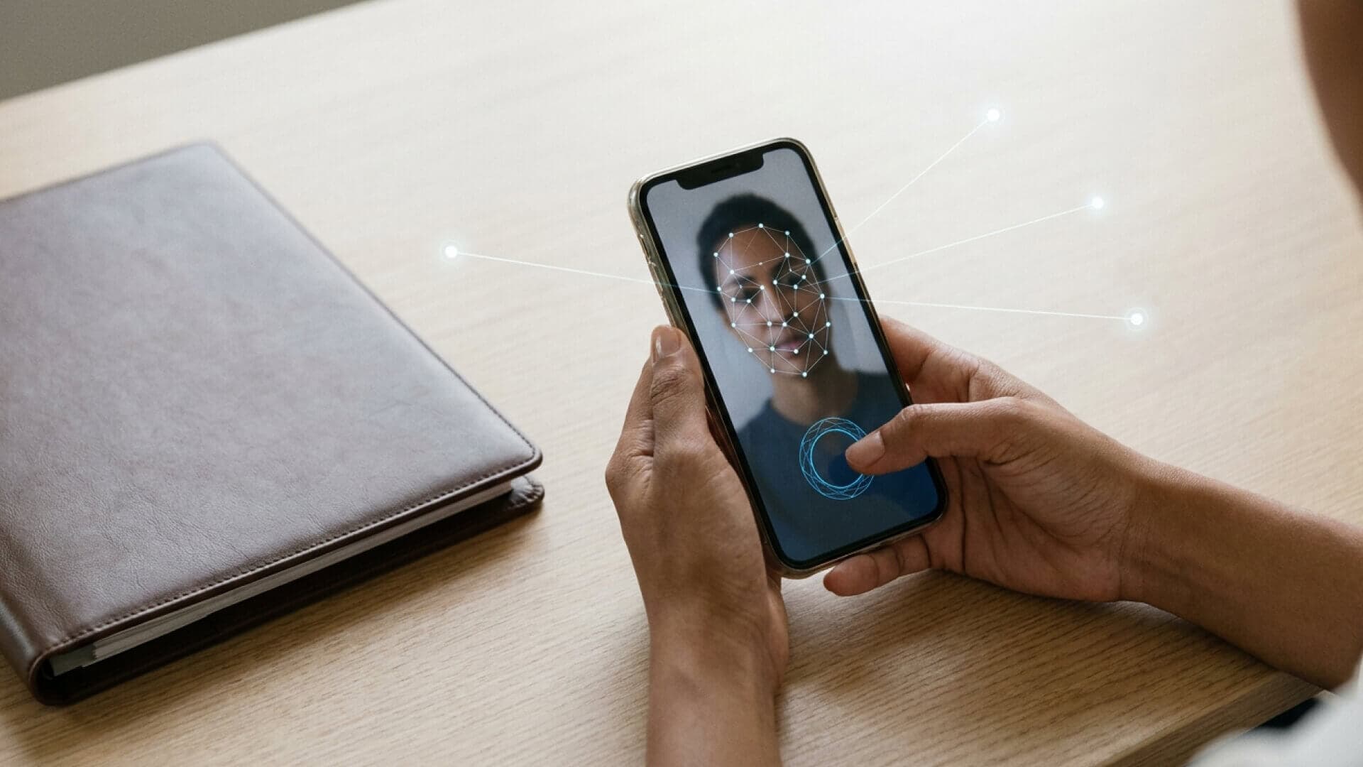 Mãos segurando um smartphone com verificação de identidade em andamento, ligado por linhas de luz a três nós de consulta, com um porta-documentos fechado ao lado.